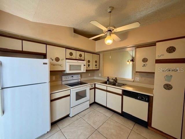 A kitchen features white cabinets, a white refrigerator, a ceiling fan, and tiled flooring — 3204 CRANES NEST LANE, KISSIMMEE, FL
