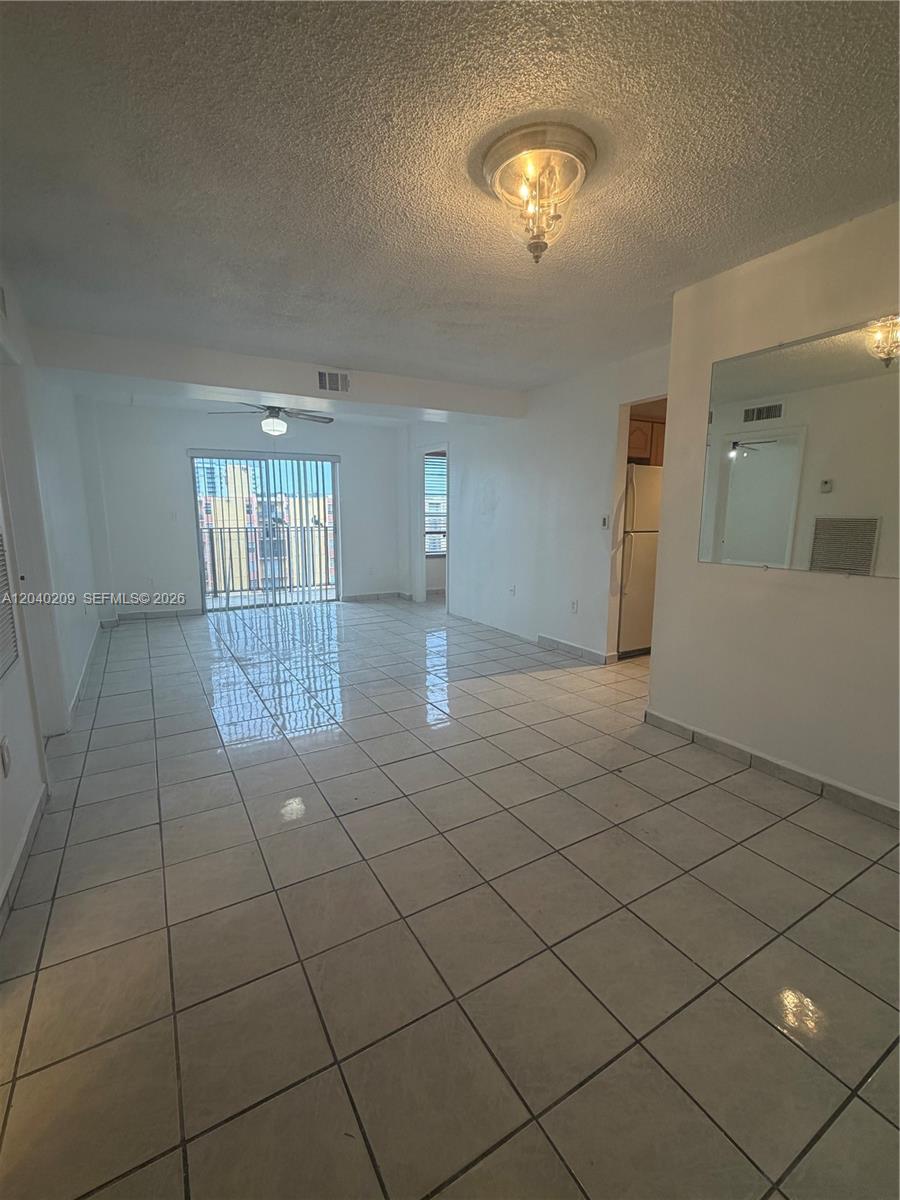 An open-concept living area features white tile flooring, a ceiling fan, and a balcony view — 4717 NW 7th St # 10, Miami FL 33126, MIAMI, FL