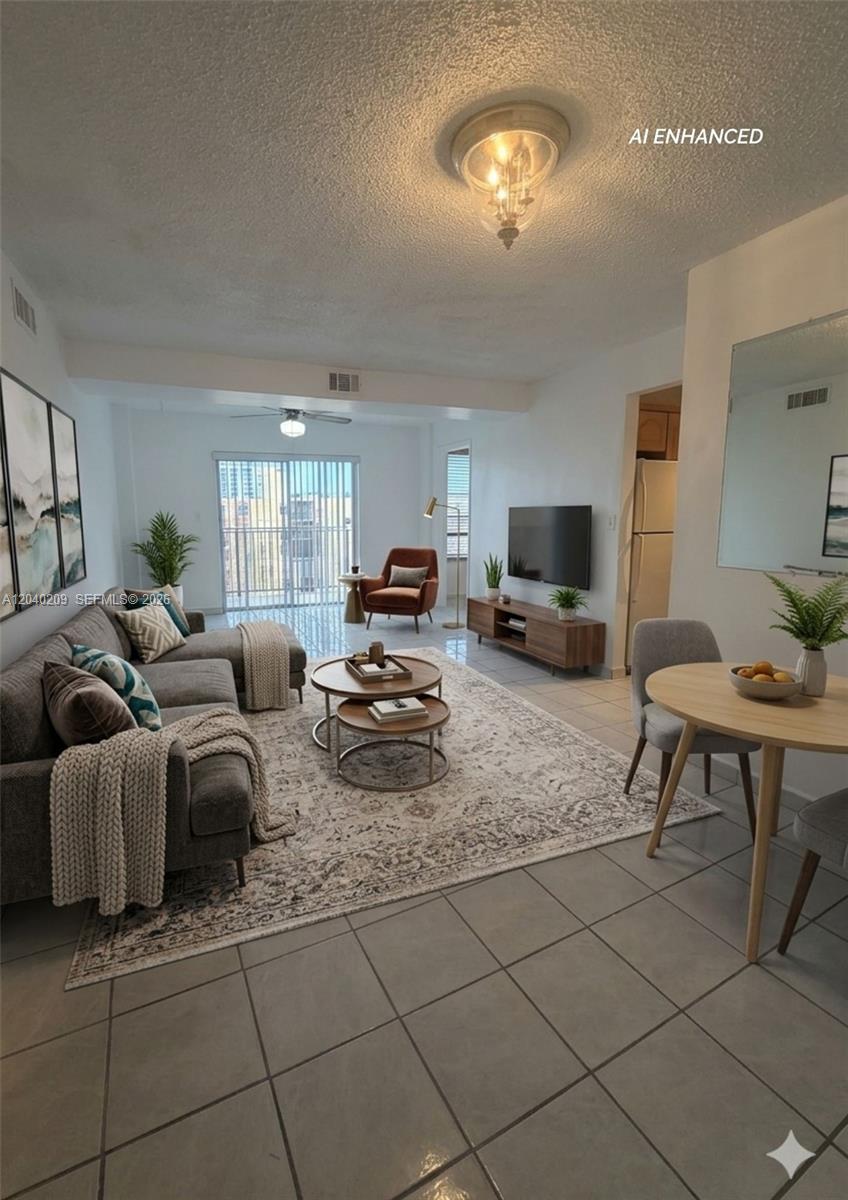 A living room with tile floors, a gray sectional sofa, and a dining area — 4717 NW 7th St # 10, Miami FL 33126, MIAMI, FL