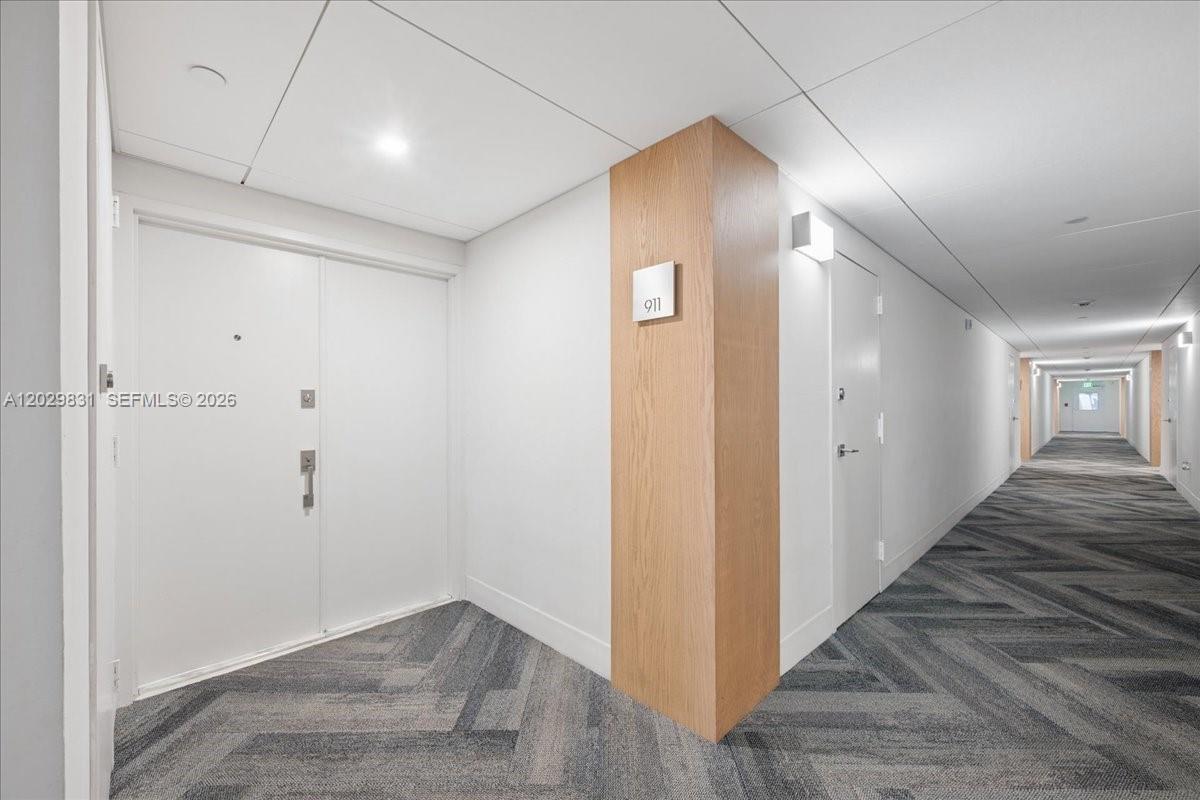 A hallway features a white double door, a wooden pillar with unit number 911, and patterned carpet — 199 Ocean Lane Dr # 911, Key Biscayne FL 33149, KEY BISCAYNE, FL