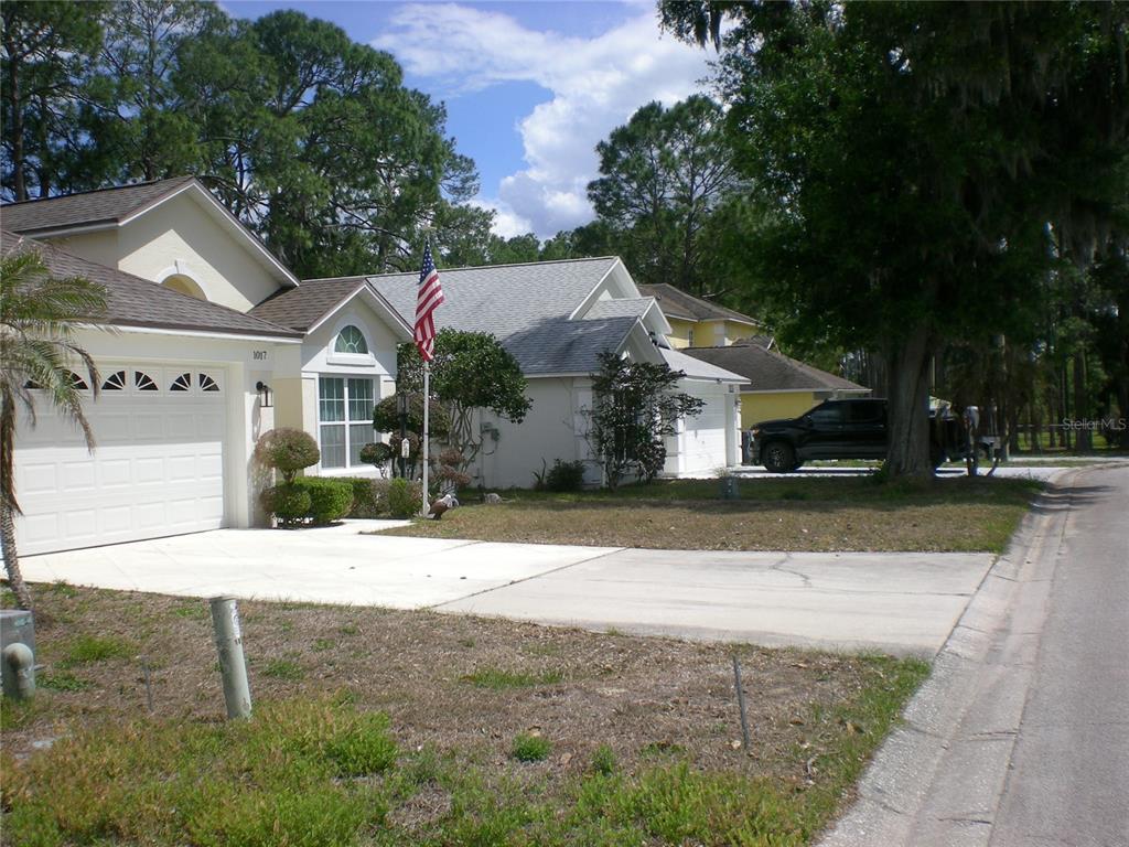 A suburban street view shows two single-story houses with driveways, lawns, and an American flag — 1026 LAKE DAVENPORT BOULEVARD, DAVENPORT, FL