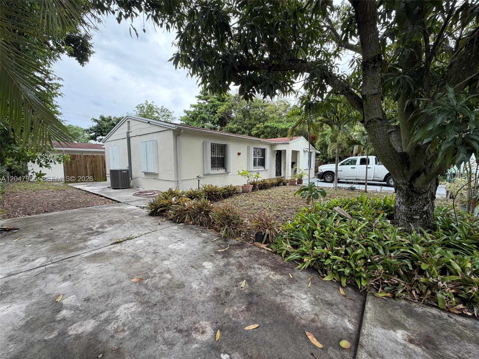 A single-story house with a concrete driveway, landscaping, and a white pickup truck parked outside — 596 NW 109th St, Miami FL 33168, MIAMI, FL