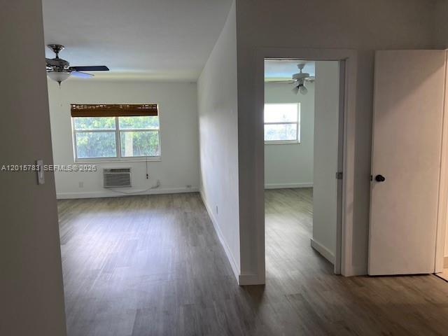 An interior view shows a living area with light wood flooring and a doorway leading elsewhere — 1350 E Sample Rd # 306, Pompano Beach FL 33064, POMPANO BEACH, FL