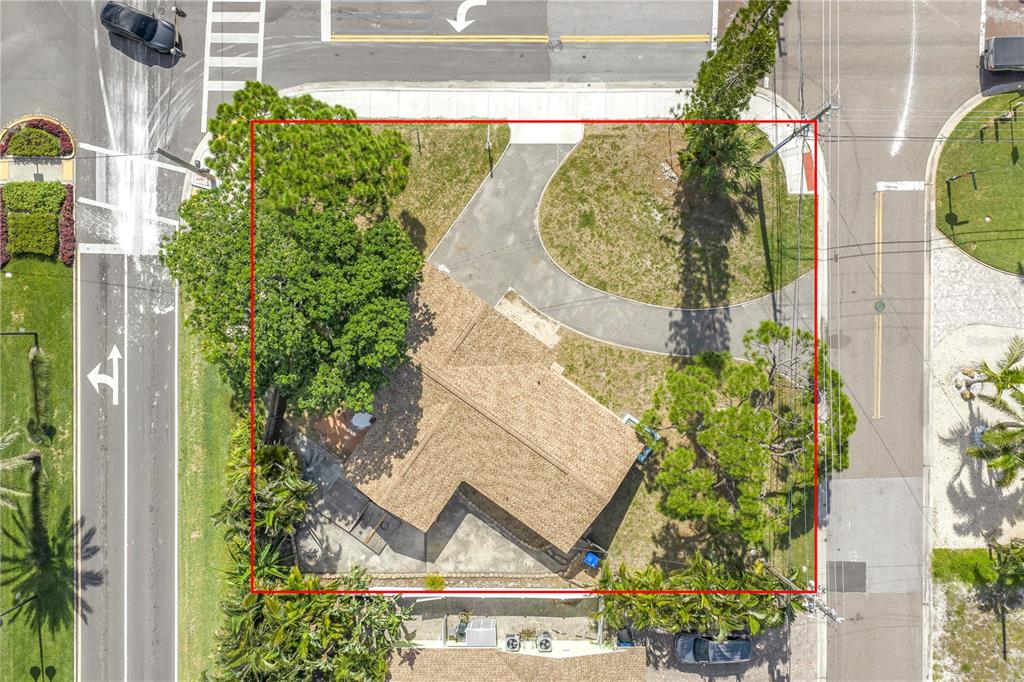 An aerial view shows a house with a shingled roof, a curved driveway, and trees — 7901 CAUSEWAY BOULEVARD S, ST PETERSBURG, FL