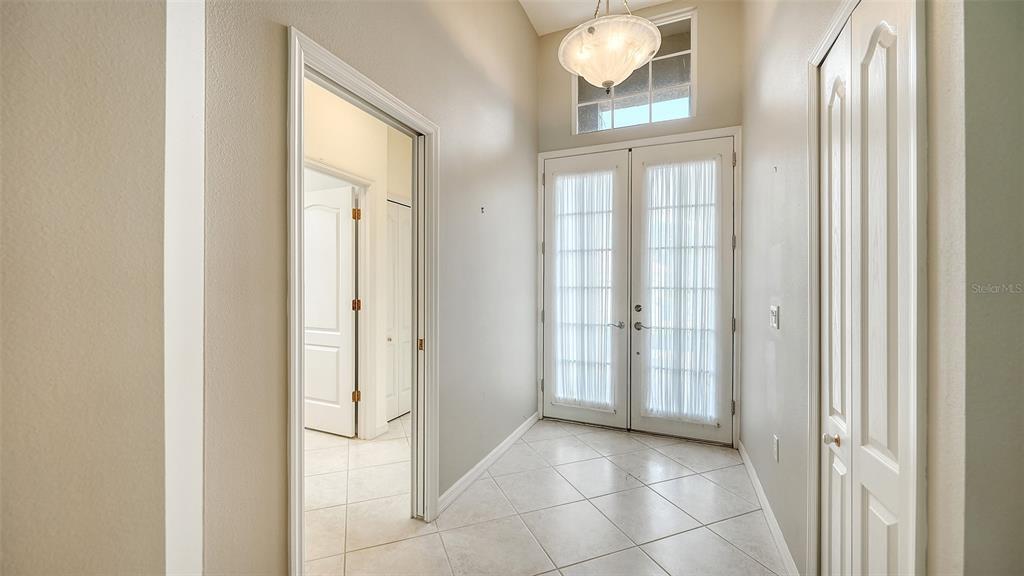 A tiled entryway features double glass doors, a transom window, and a light fixture — 8224 NICE WAY, SARASOTA, FL