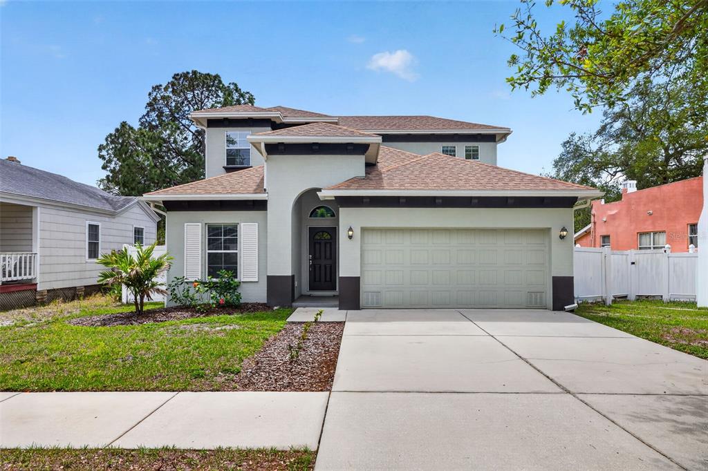 A two-story house with a light-colored stucco exterior, a two-car garage, and a shingled roof — 3204 W MARLIN AVENUE, TAMPA, FL