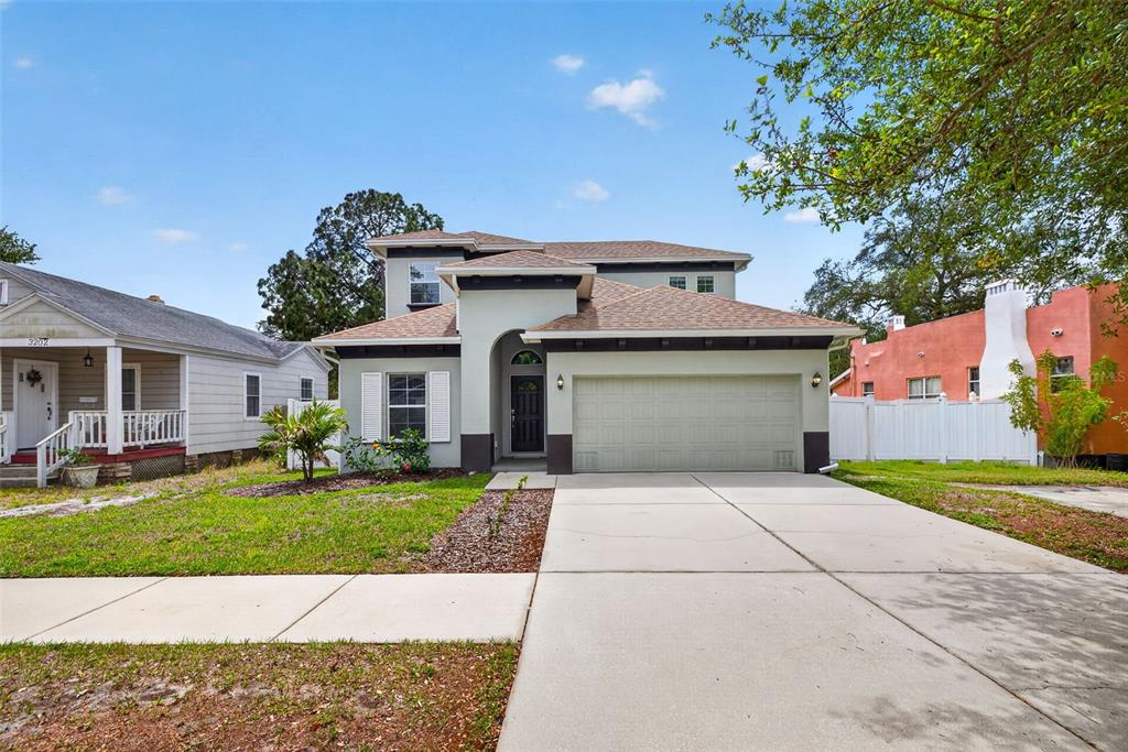 A two-story house with a light-colored stucco exterior, a two-car garage, and a driveway — 3204 W MARLIN AVENUE, TAMPA, FL