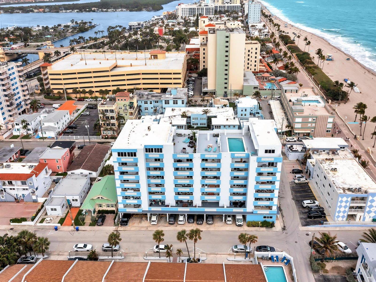 An aerial view of a multi-story apartment building with a rooftop pool and parking area — 320 S Surf Road # 205, Hollywood FL 33019, HOLLYWOOD, FL
