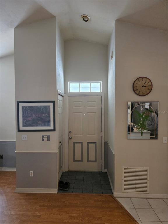 An entryway features a white front door with a transom window and two-toned wall paint — 1931 SW 73RD STREET, GAINESVILLE, FL
