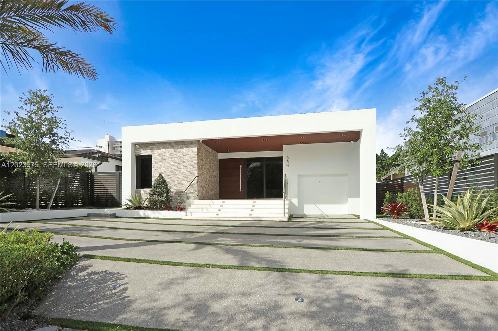 A modern single-story house features a stone facade, white exterior walls, and a paved driveway — 330 SW 19th Rd, Miami FL 33129, MIAMI, FL