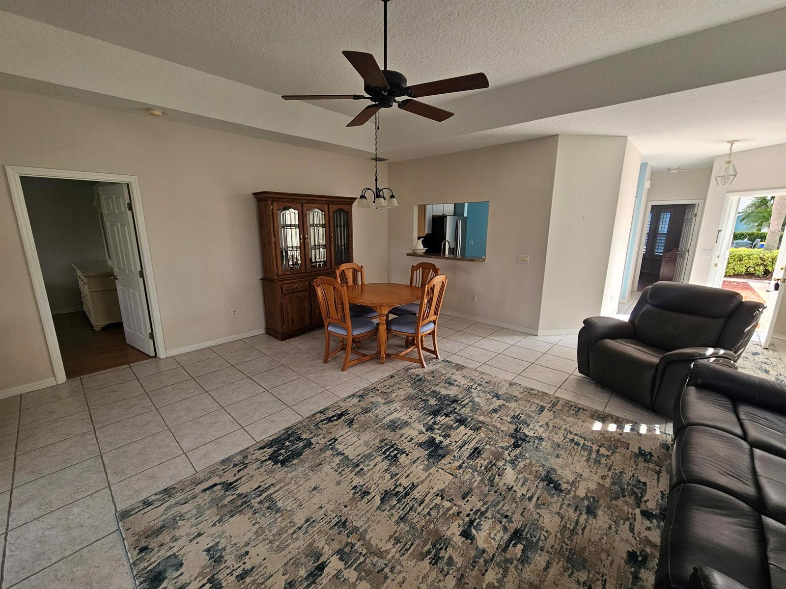 A dining area with a wooden hutch and table sits adjacent to a living room — 4011 Gator Trace Road, Fort Pierce FL 34982, FORT PIERCE, FL