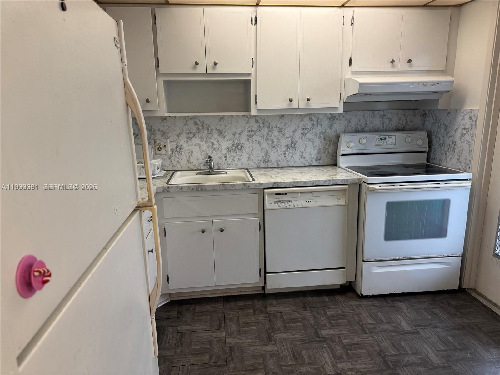 A kitchen features white cabinets, a white stove, a dishwasher, and a marble-patterned countertop — 950 Hillcrest Dr # 411, Hollywood FL 33021, HOLLYWOOD, FL