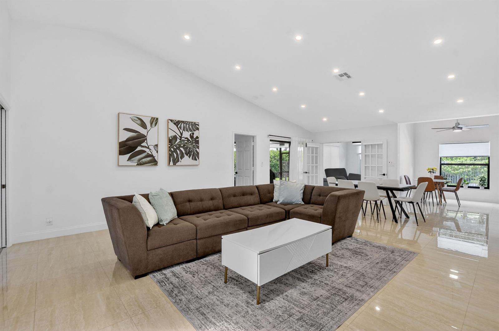 A living room features a brown sectional sofa, a white coffee table, and tile flooring — 19700 Sedgefield Terrace, Boca Raton FL 33498, BOCA RATON, FL