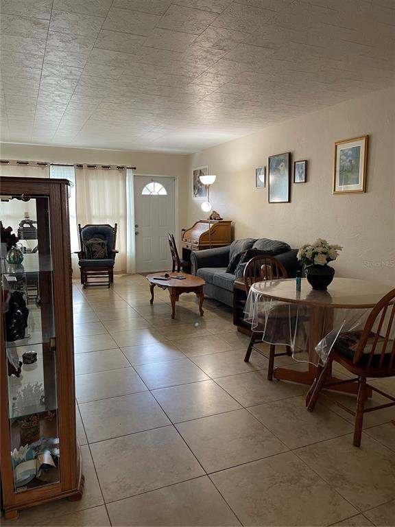 A living and dining room area features tile flooring, a sofa, and a round table — 4144 57TH STREET N UNIT 269, KENNETH CITY, FL