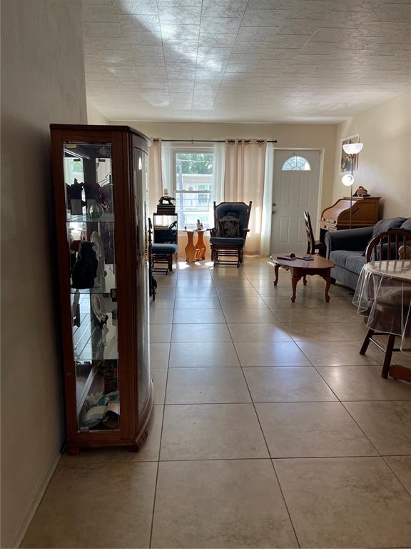 A living room features light-colored tile flooring, a glass display cabinet, and a window — 4144 57TH STREET N UNIT 269, KENNETH CITY, FL