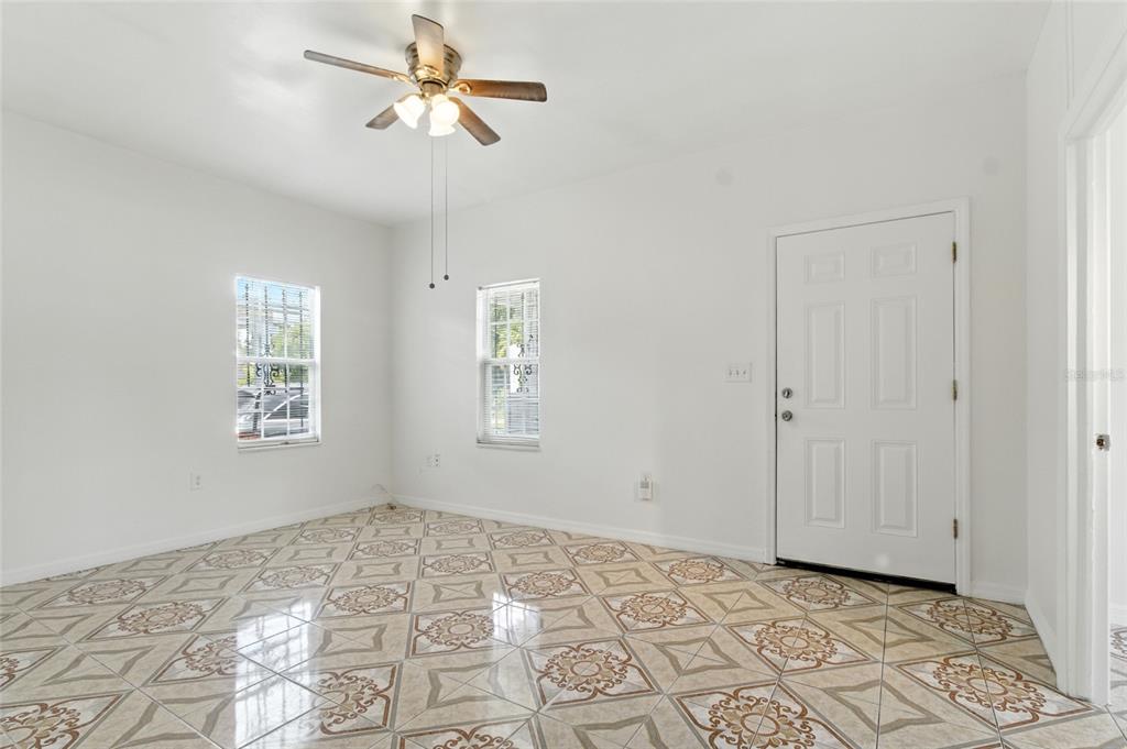 An empty room with white walls, a ceiling fan, and patterned tile flooring — 1303 E 26TH AVENUE, TAMPA, FL