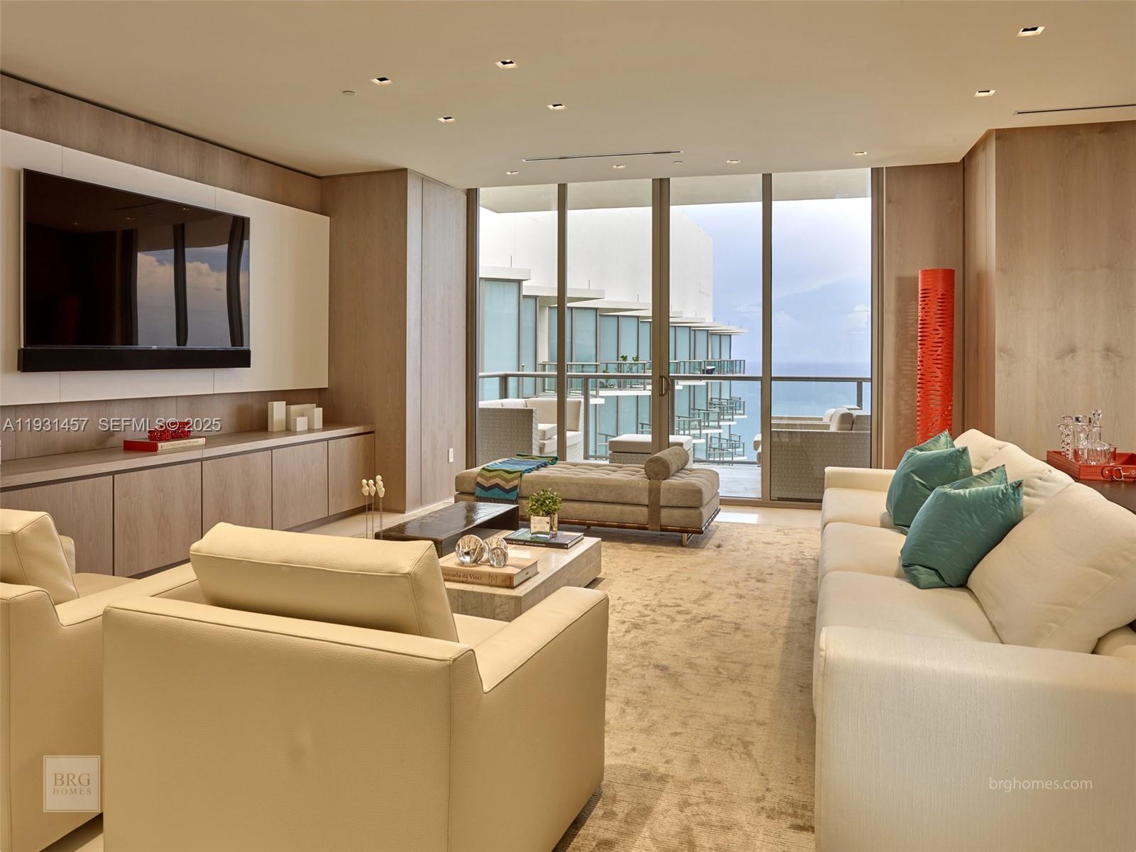 A modern living room features light wood paneling, a large television, and floor-to-ceiling balcony windows — 9701 Collins Ave # 2704S, Bal Harbour FL 33154, BAL HARBOUR, FL