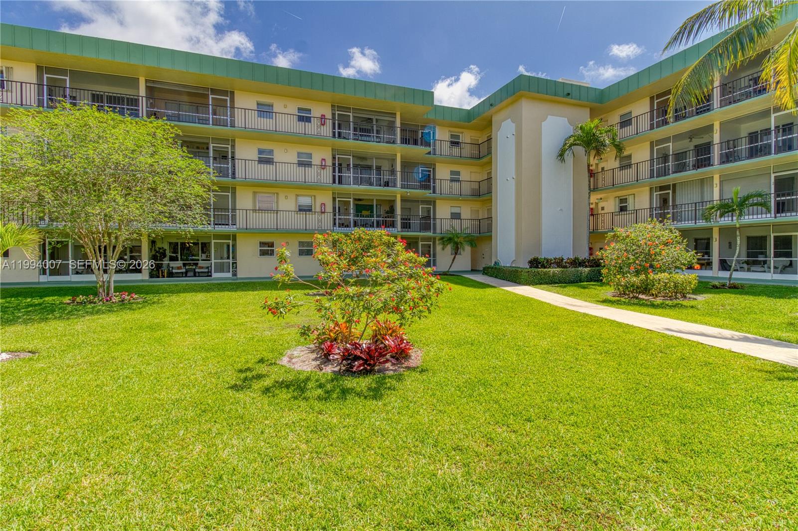 An open-concept living and dining area features light wood-look flooring and a ceiling fan — 804 SE 7th St # 107, Deerfield Beach FL 33441, DEERFIELD BEACH, FL