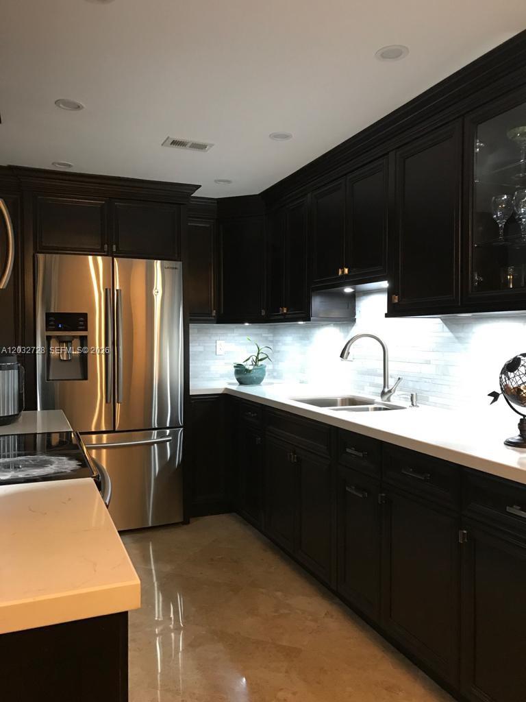 A kitchen features dark wood cabinets, stainless steel appliances, and white countertops — 1300 SW 122nd Ave # 2, Miami FL 33184, MIAMI, FL