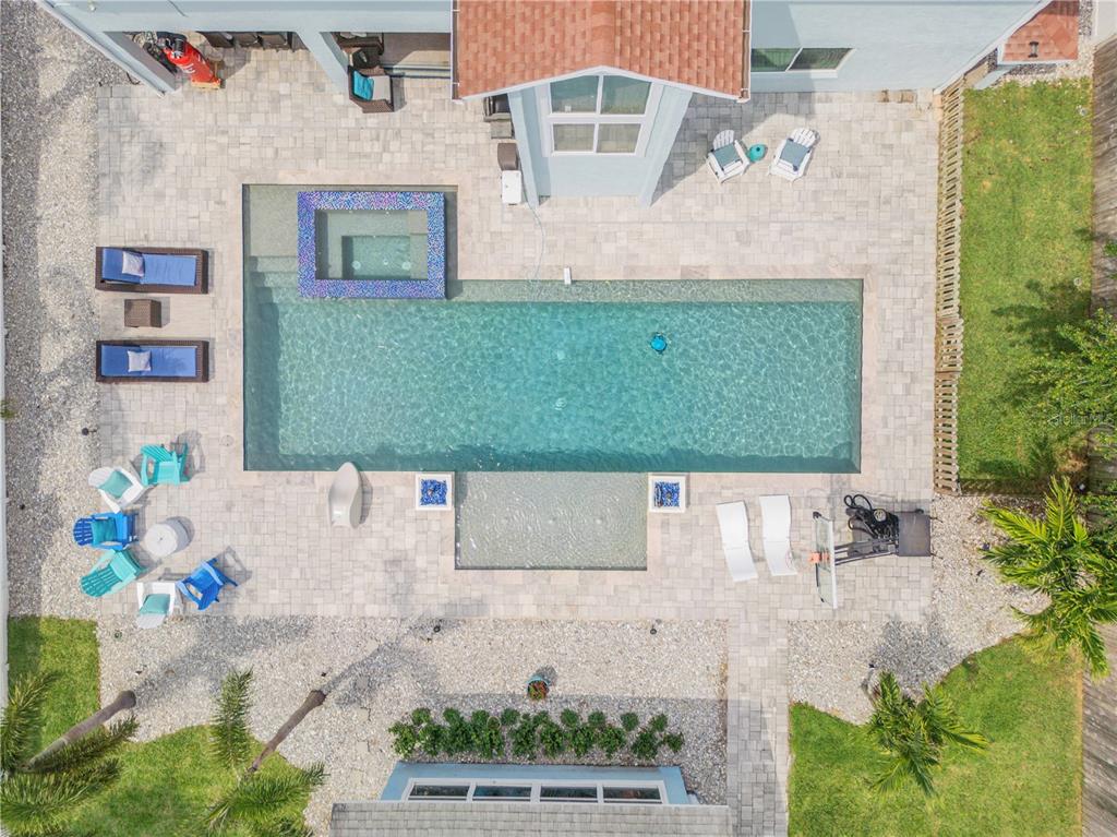 An aerial view of a backyard featuring a rectangular swimming pool, spa, and patio furniture — 90 CUNNINGHAM DRIVE, NEW SMYRNA BEACH, FL