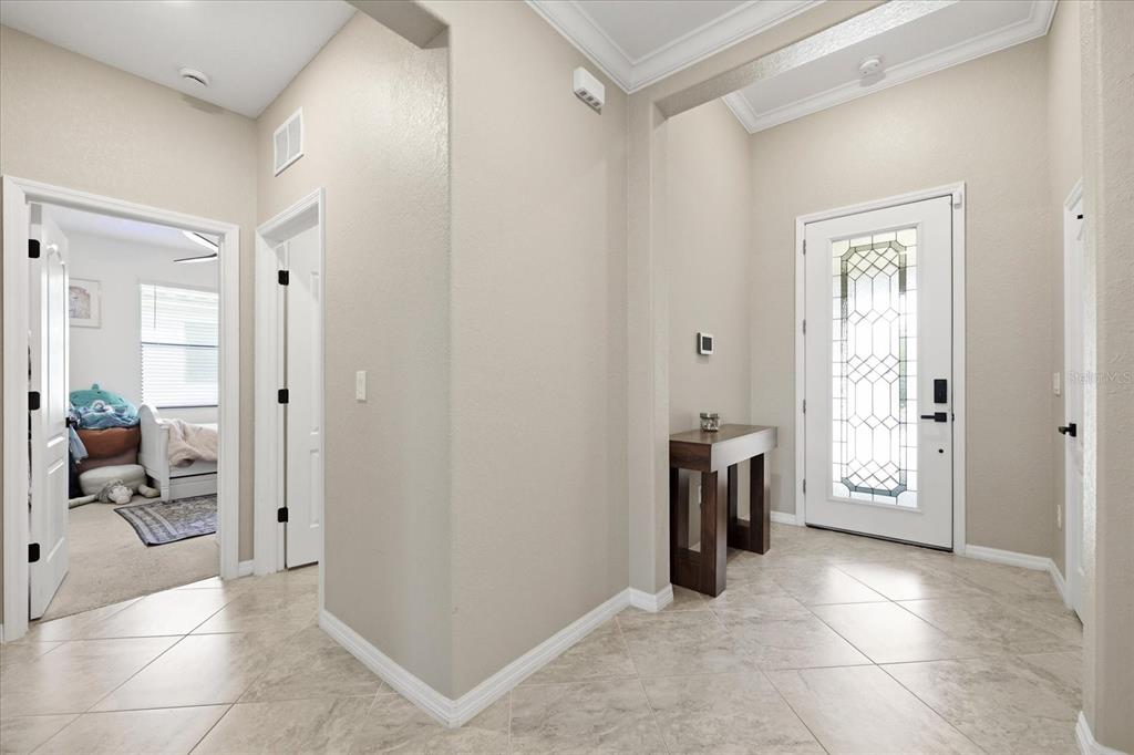 An entryway features a tiled floor, a white front door with glass, and a console table — 17234 BLUE RIDGE PLACE, BRADENTON, FL