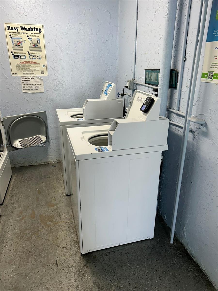 A laundry room features two white top-load washing machines against a light blue wall — 500 NE 2nd St # 310, Dania Beach FL 33004, DANIA BEACH, FL