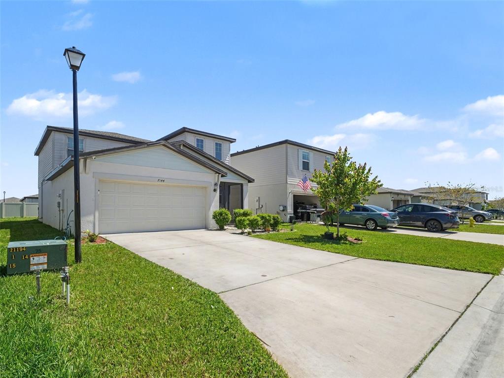 A kitchen features dark wood cabinets, granite countertops, a center island, and white bar stools — 7144 BOGGY CREEK PLACE, PARRISH, FL