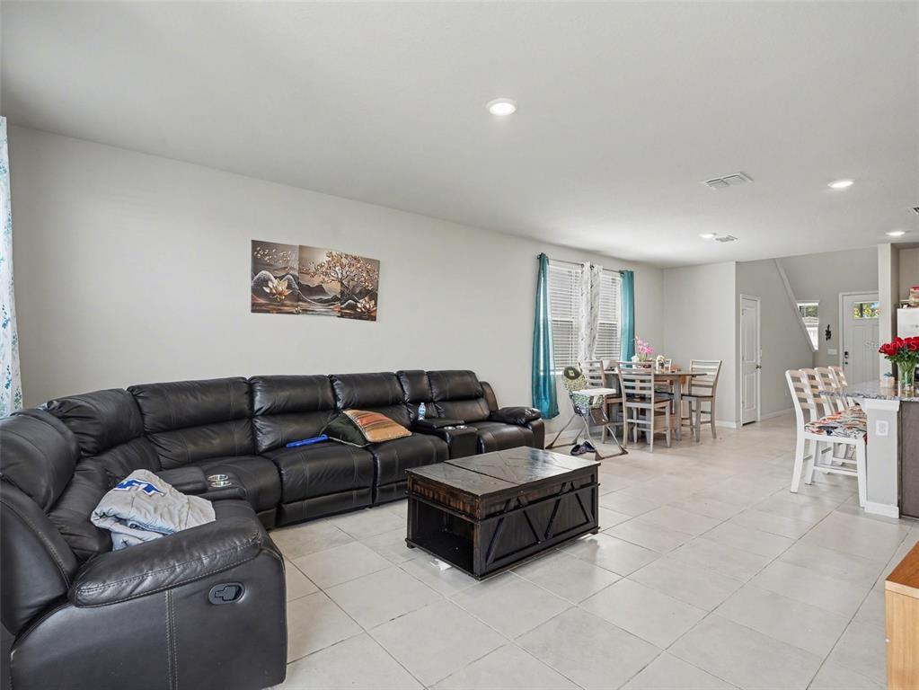 A dining area with a round wooden table, four chairs, and tile flooring — 7144 BOGGY CREEK PLACE, PARRISH, FL