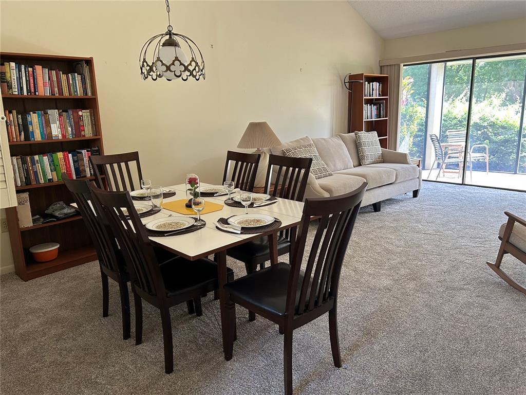 A fenced outdoor swimming pool is surrounded by green grass and tall trees — 5204 MYRTLE WOOD UNIT 2, SARASOTA, FL