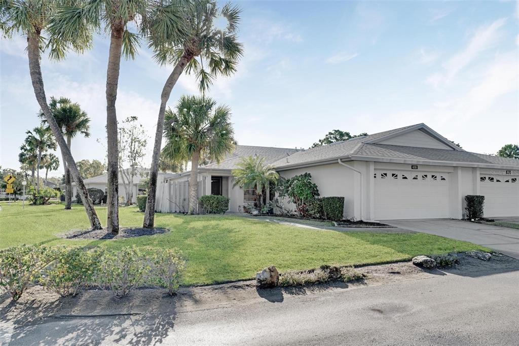 A single-story house with a two-car garage, palm trees, and a grassy front lawn — 4201 CENTER GATE LANE UNIT 1, SARASOTA, FL