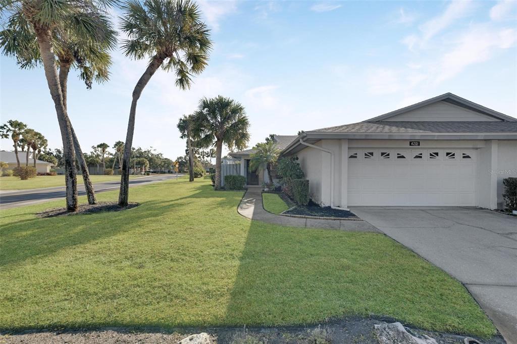 A single-story house with a white garage, a concrete walkway, and palm trees in front — 4201 CENTER GATE LANE UNIT 1, SARASOTA, FL