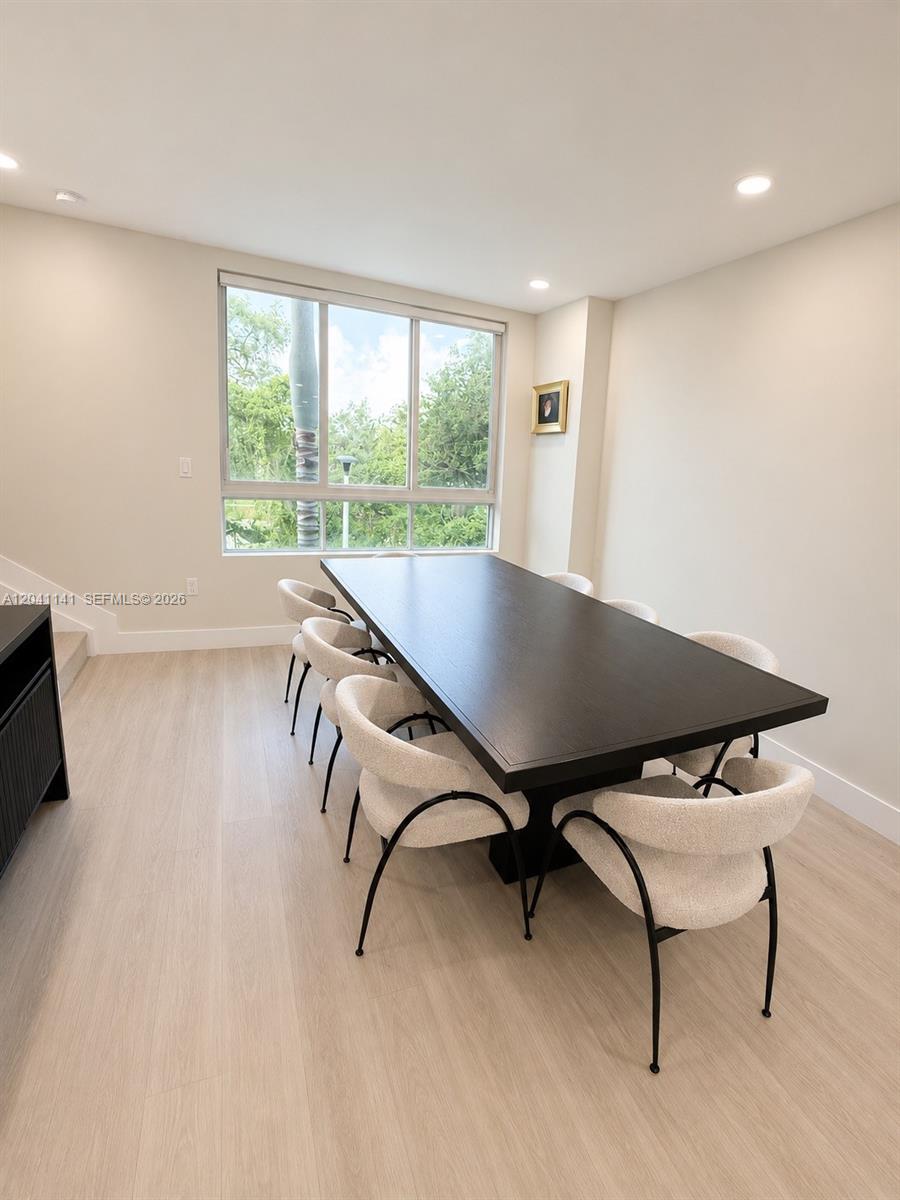A dining room features a long dark wood table, cream-colored chairs, and light wood flooring — 2505 NE 193rd St # 4211, Miami FL 33180, MIAMI, FL