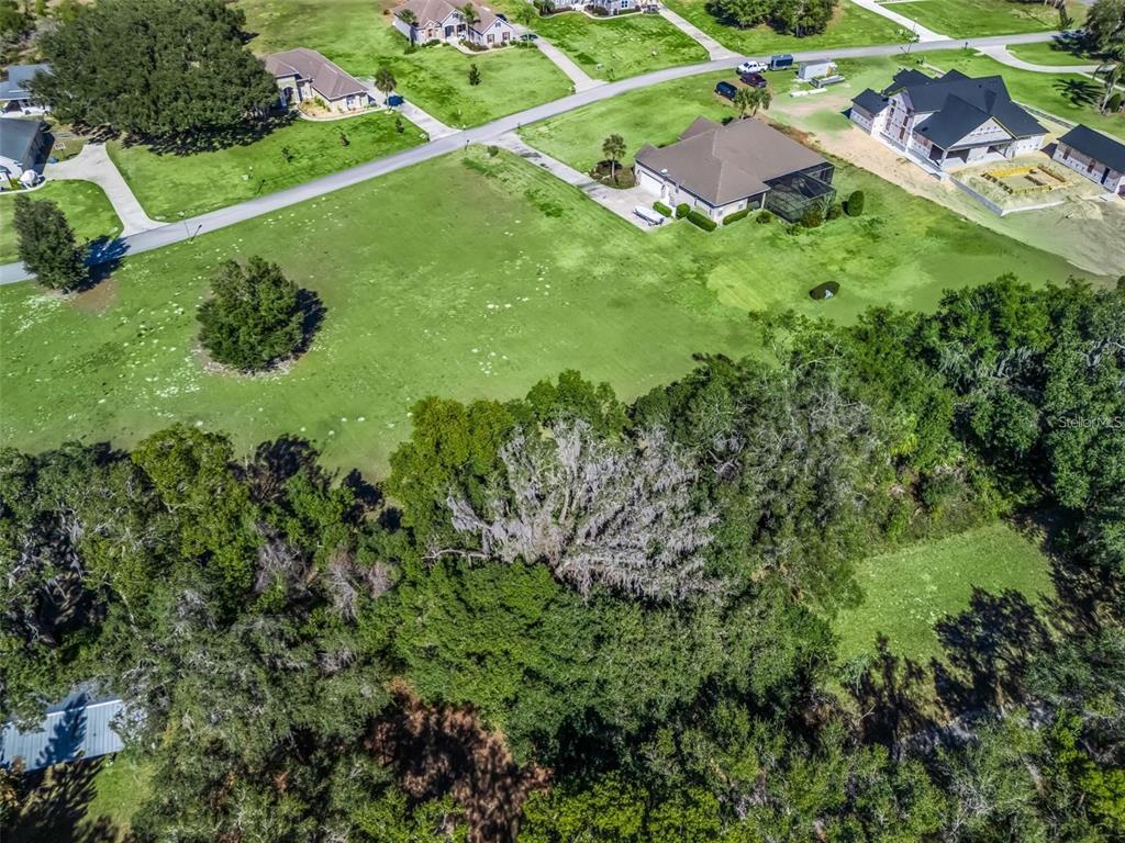 An aerial view shows a large grassy lot with a house and surrounding trees — SE 156TH LANE, WEIRSDALE, FL