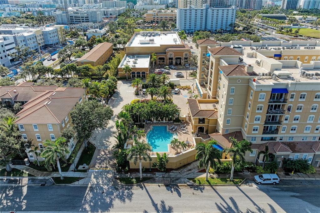 An aerial view shows a multi-story apartment complex with a central swimming pool and courtyard — 1064 N TAMIAMI TRAIL UNIT 1304, SARASOTA, FL