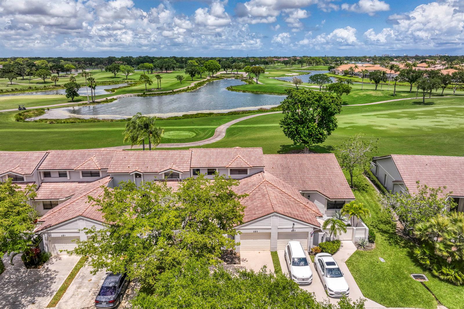 An aerial view shows a multi-unit residential building overlooking a golf course and lake — 495 Prestwick Circle, Palm Beach Gardens FL 33418, PALM BEACH GARDENS, FL
