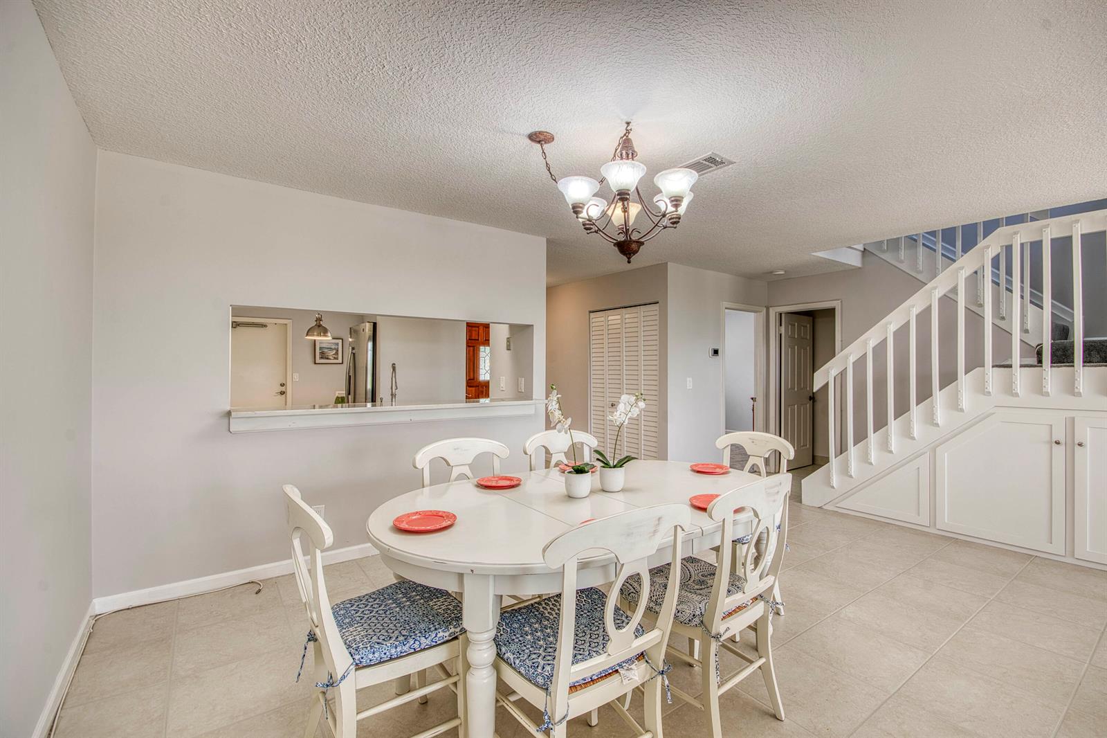 A dining area with a white table, six chairs, and a staircase to the right — 495 Prestwick Circle, Palm Beach Gardens FL 33418, PALM BEACH GARDENS, FL