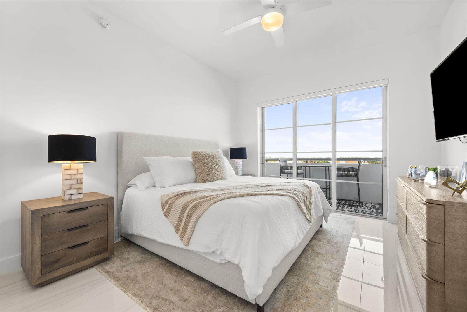 A bedroom with a queen bed, two nightstands, a dresser, and a balcony with outdoor seating — 155 E Boca Raton Road # 919, Boca Raton FL 33432, BOCA RATON, FL