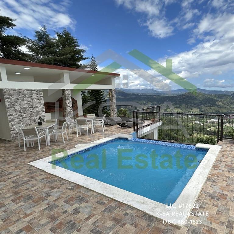 A swimming pool sits on a tiled patio overlooking a mountain landscape — JAMACA DE DIOS CARRETERA PALO BLANCO, JARABACOA, KY