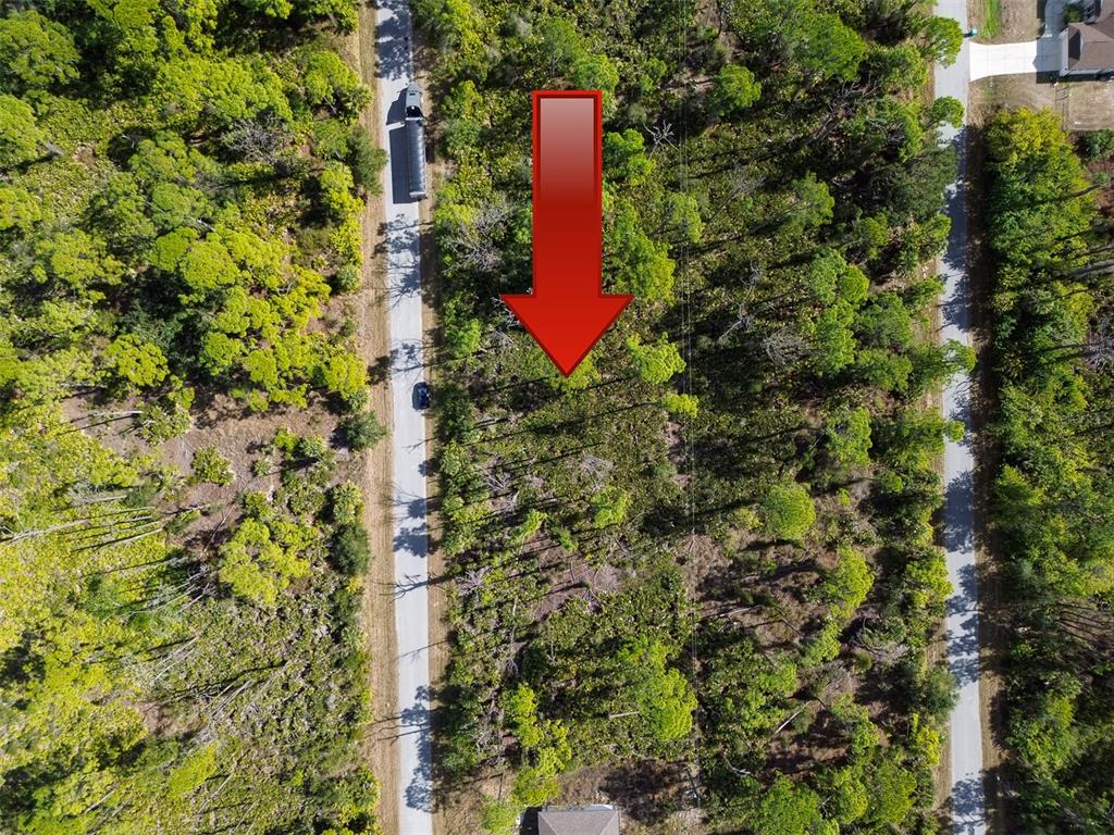 An aerial view shows a wooded lot situated between two paved roads — 13345 HARTH AVENUE, PORT CHARLOTTE, FL