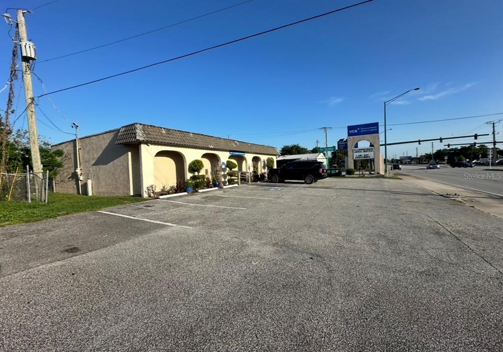 A single-story commercial building with a parking lot sits along a road under clear skies — 1104 S NOVA ROAD, ORMOND BEACH, FL