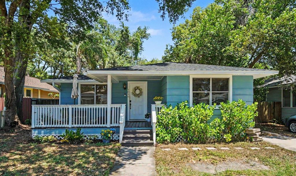 A single-story blue house with a white front porch and a concrete walkway — 1016 E EMMA STREET, TAMPA, FL