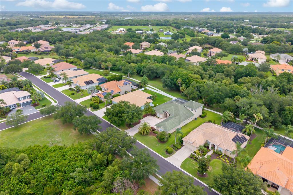 An aerial view shows a single-family home circled in a residential neighborhood with lakes — 12471 NATUREVIEW CIRCLE, BRADENTON, FL