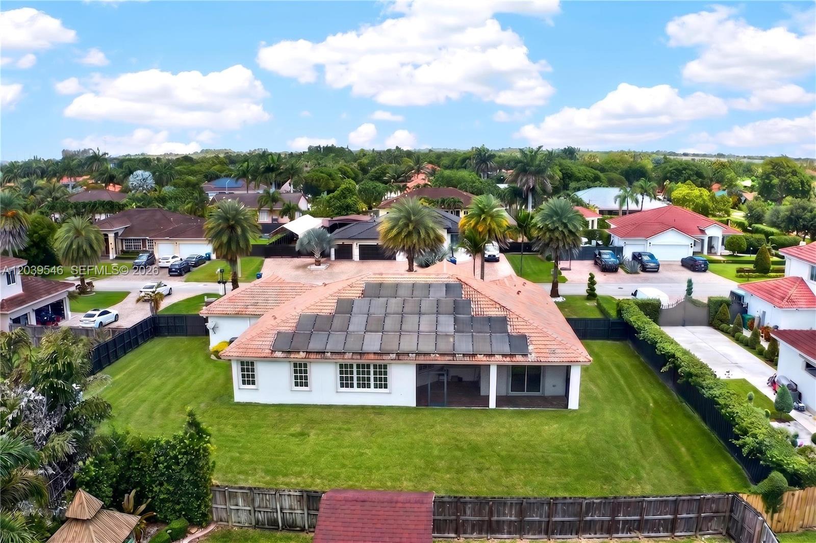 An aerial view shows a single-story house with solar panels on a tiled roof — 12922 SW 221 St, Miami FL 33170, MIAMI, FL