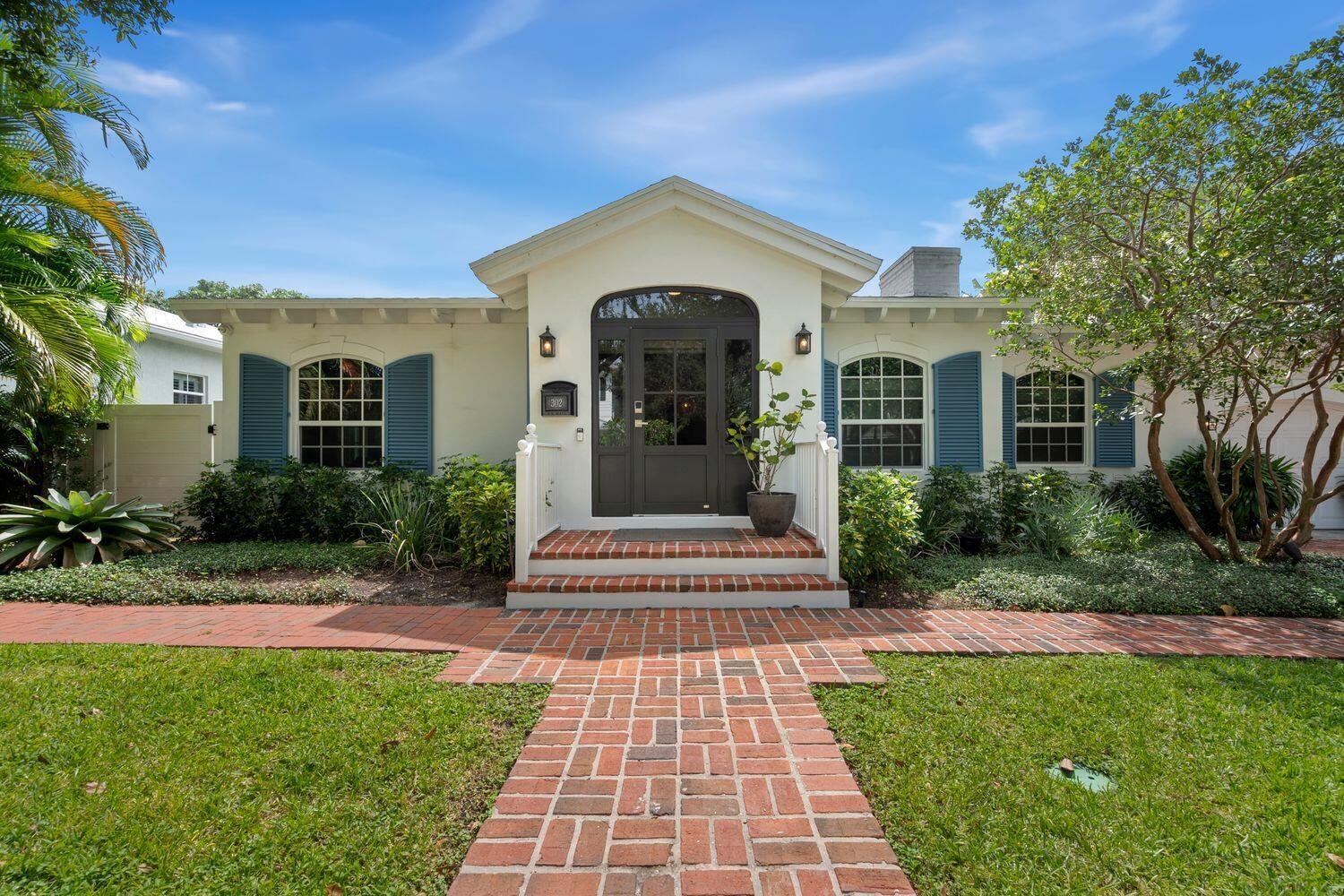 A single-story house with a brick walkway, blue shutters, and a central arched front door — 302 NW 16th Street, Delray Beach FL 33444, DELRAY BEACH, FL