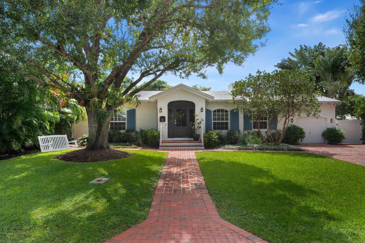 A single-story house with a brick walkway, blue shutters, and a large tree in front — 302 NW 16th Street, Delray Beach FL 33444, DELRAY BEACH, FL