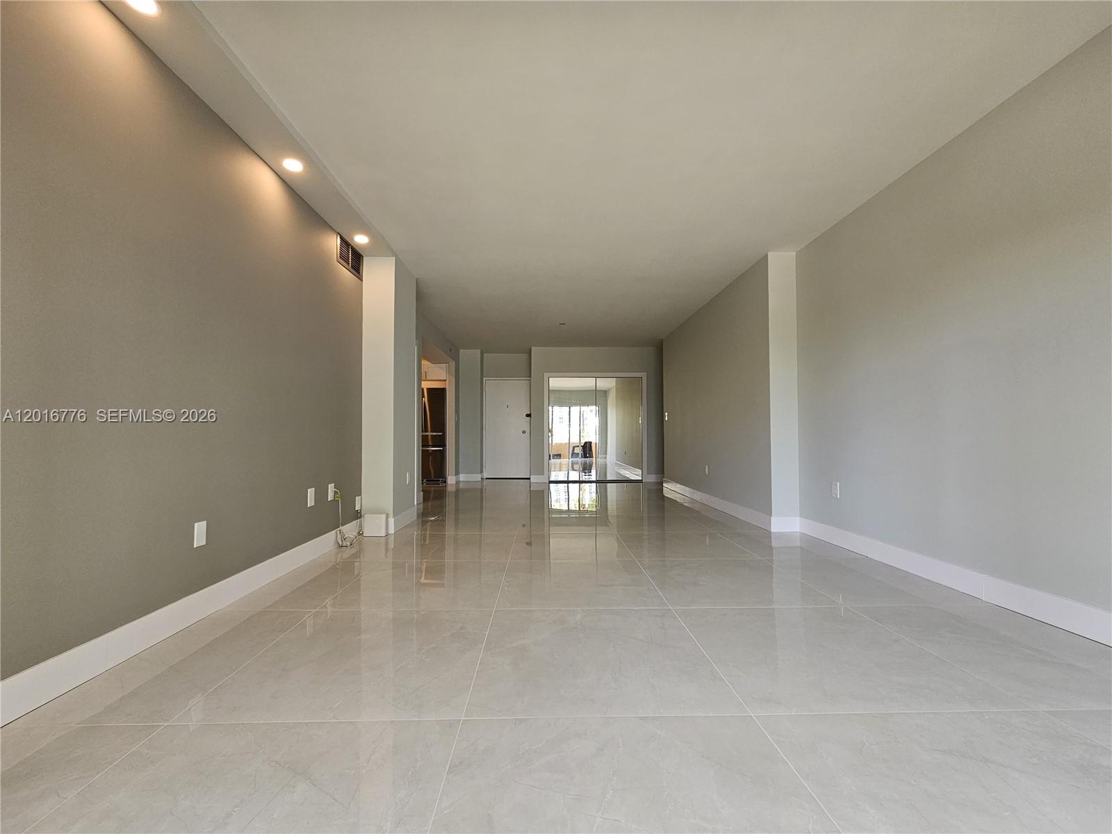 An empty room features gray walls, large light-colored floor tiles, and recessed ceiling lighting — 1985 S Ocean Dr # 2K, Hallandale Beach FL 33009, HALLANDALE BEACH, FL