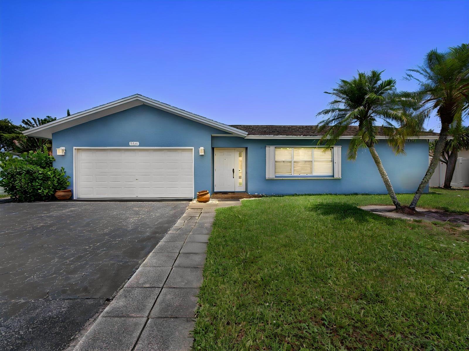 A single-story blue house with a white garage door, front door, and a palm tree — 108 Orchard Ridge Lane, Boca Raton FL 33431, BOCA RATON, FL