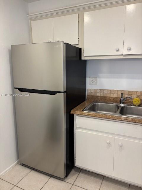 A kitchen features a stainless steel refrigerator next to a double-basin sink and white cabinets — 9493 SW 76th St # L4, Miami FL 33173, MIAMI, FL