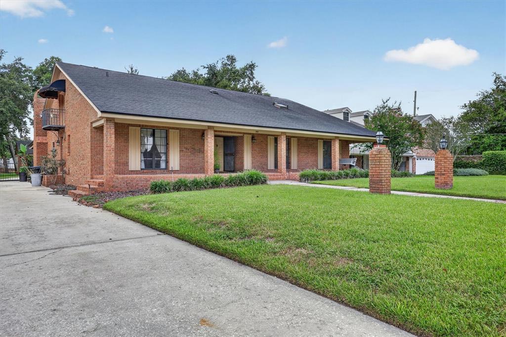 A single-story brick house with a dark shingled roof and a front porch — 306 OAK ESTATES DRIVE, ORLANDO, FL