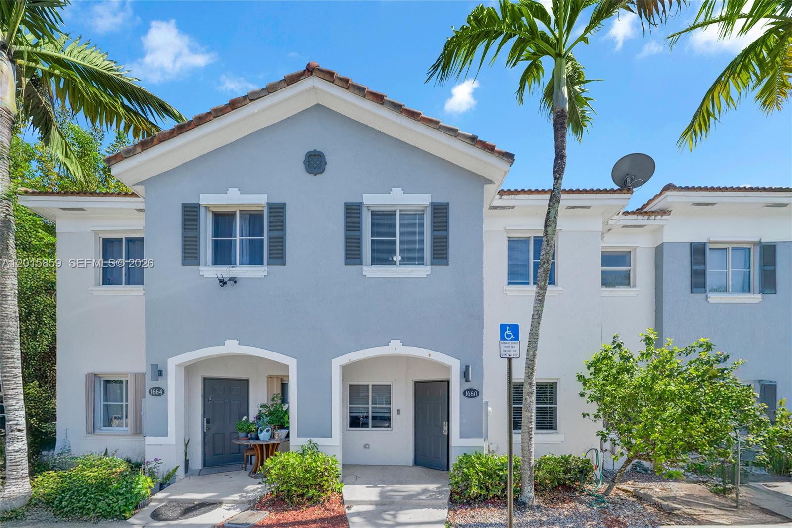 The exterior of a two-story townhouse with a blue facade and a palm tree — 1660 SE 30th St, Homestead FL 33035, HOMESTEAD, FL